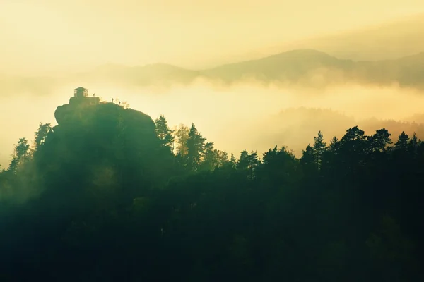 ボヘミアンスイス公園の秋の谷で冷たい霧の夜明け。丘の上の小屋魔法の暗闇から増加. — ストック写真