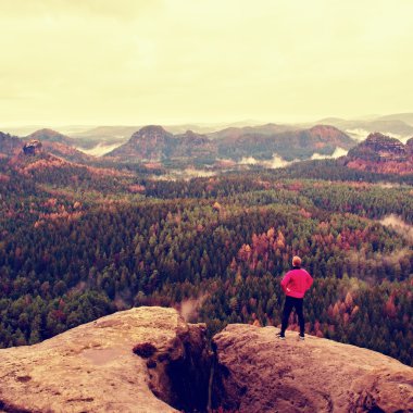 Runner pembe ceket ve ışık siyah pantolon. Onun hedefi kısa Kızıl saçlı adam. Yorgun sporcu kayalarda makul bir dinlenme almak.