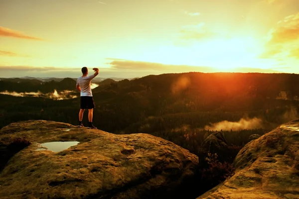 Runner man in his target with hand in the air. Sweaty man in black pants and white sweaty t-shirt, — Stock Photo, Image