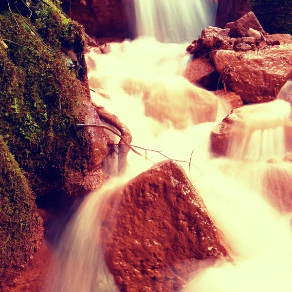 Cascades in snelle stroom van mineraalwater. Rode ijzer(III) sedimenten op grote rotsen — Stockfoto