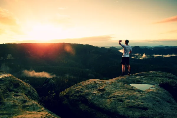 Runner man in his target with hand in the air. Sweaty man in black pants and white sweaty t-shirt, — Stock Photo, Image