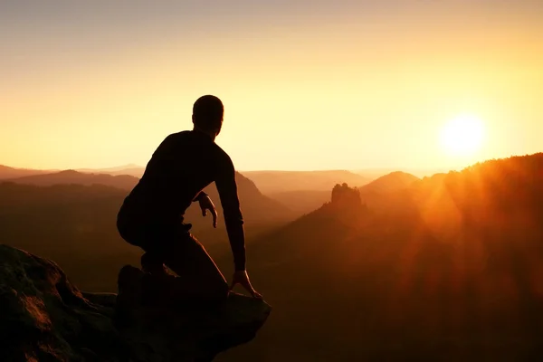 Senderista tomar relajarse en una roca y disfrutar de la puesta de sol en el horizonte. Efecto vívido . — Foto de Stock