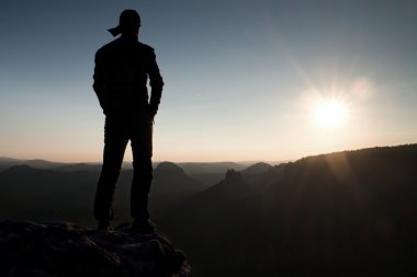 Uzun yürüyüşe çıkan kimse rock İmparatorluğu ve doğa mucizesi güneş güzel anı izlerken uzun şapkalı 