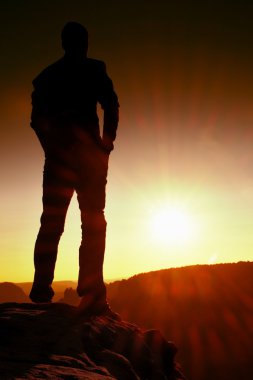 Elleri kalça, sabah veya geç gün güneş kopya alanı ile olan ayakta genç kendinden emin ve güçlü adam silüeti