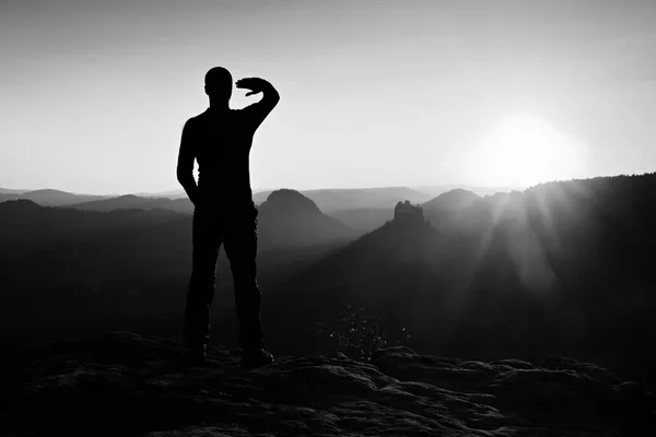 Jovem desportista sombreando seus olhos de raios brilhantes de sol amanhecer — Fotografia de Stock