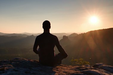 Uzun yürüyüşe çıkan kimse bir kayaya çömelme pozisyonda dybreak sahne tadını çıkarın