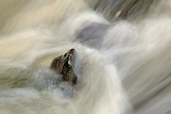 Slippery boulders in mountain stream. Clear water blurred by long exposure, reflection in water level. Soft focus. — Stock Photo, Image