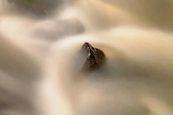 Rochers glissants dans le ruisseau de montagne. Eau claire brouillée par une longue exposition, réflexion dans le niveau de l'eau. Concentration douce . — Photo