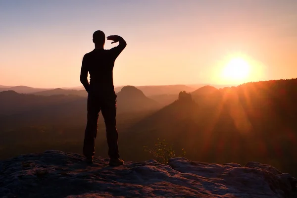 Young sportsman shadowing his eyes from bright rays of daybreak Sun — Stock Photo, Image