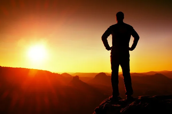 Silueta de hombre joven confiado y poderoso de pie con las manos en las caderas, el sol de la mañana o del último día con espacio de copia Fotos de stock