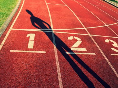 Atlet karanlık keskin vücut Gölge on kırmızı bir koşu parkuru Stadyumu