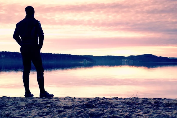 Silhouette of alone person on  decline seeing over bay to sun — Stock Photo, Image