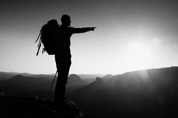 Αιχμηρά σιλουέτα του ένας ψηλός άνδρας στην κορυφή του βουνού με ήλιο στο πλαίσιο. Τουριστικός οδηγός στα βουνά — Φωτογραφία Αρχείου