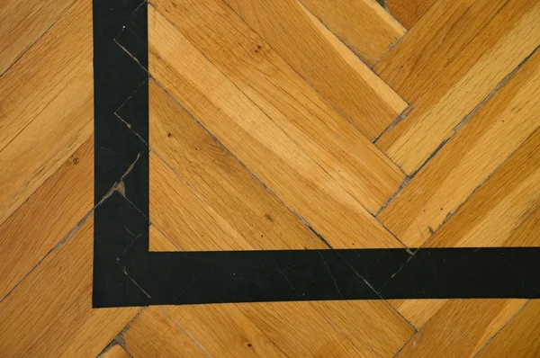 Black corner. Worn out wooden floor of sports hall with marking lines — Stock Photo, Image