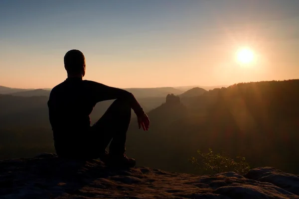 Wanderer entspannen sich auf einem Felsen und genießen den Sonnenuntergang am Horizont. Lebendige Wirkung. — Stockfoto