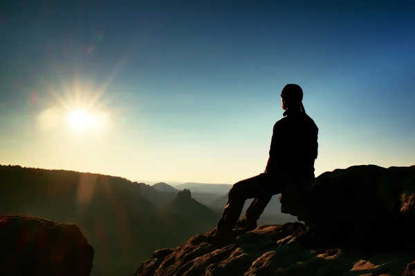 Wanderer entspannen sich auf einem Felsen und genießen den Sonnenuntergang am Horizont. Lebendige Wirkung. — Stockfoto