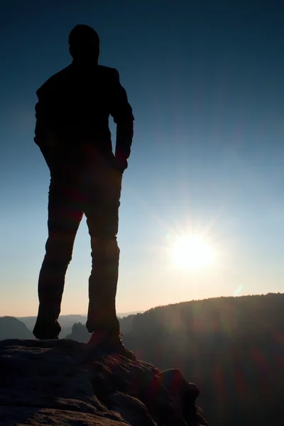 Ein Mann hat seine Hände auf den Hüften. Sportler-Silhouette in der Natur bei Tagesanbruch. — Stockfoto