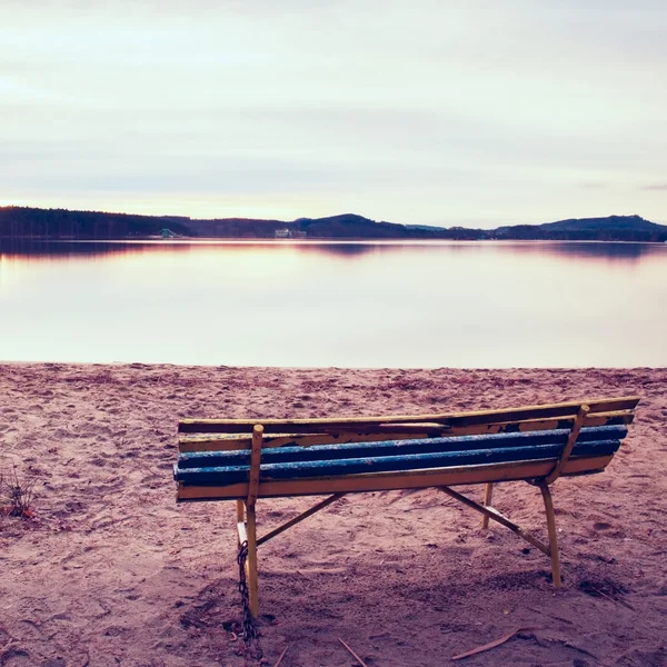 Soirée d'automne colorée. Banc en bois vide sur la plage du lac . — Photo