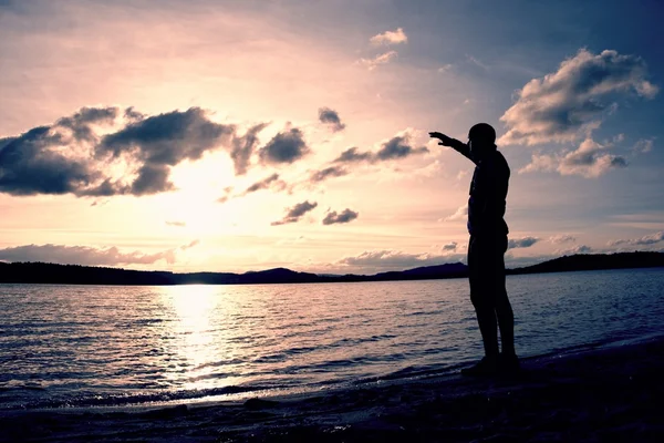 日没、平和な水位を見てビーチのそば男スタンド — ストック写真