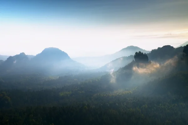 Heavy misty daybreak. Misty daybreak in a beautiful hills. Peaks of hills are sticking out from foggy background. — Stock Photo, Image