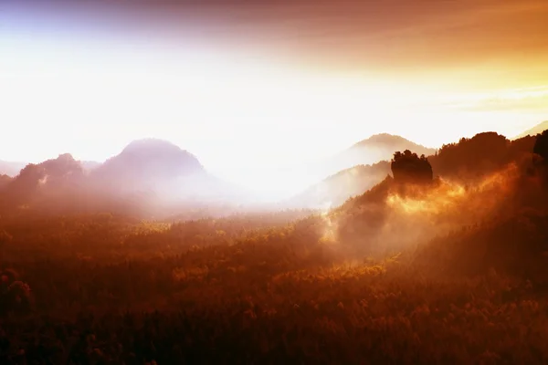 Filtre rouge photo. L'aube rouge. Coucher de soleil brumeux dans une belle colline. Des sommets de collines sortent du brouillard rouge et orange — Photo