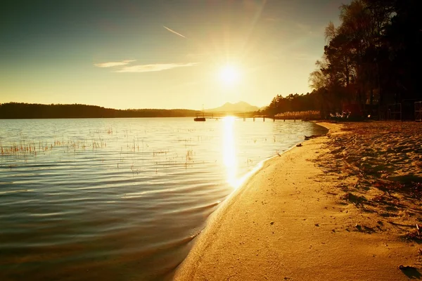 Kıyı, terk edilmiş iskele, renkli sonbahar gündoğumu. Ufuk kalesine ile ada. — Stok fotoğraf