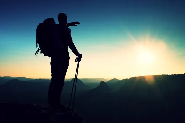 Turist på topp. Soluppgång med inversion. Klippa ovanför djupt höst dalen med turistguide på toppen. Fotvandrare watch hisnande vackra landskap — Stockfoto