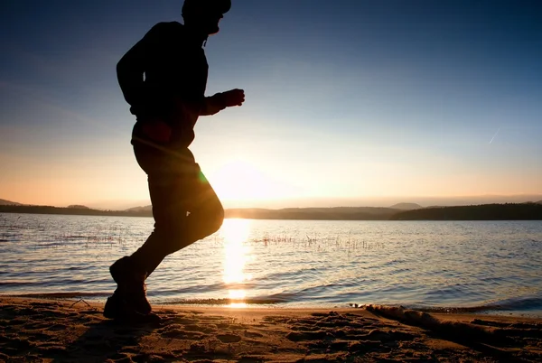 Kolejny mężczyzna na plaży. Sportowca w czapka z daszkiem, jogging facet podczas sunrise — Zdjęcie stockowe