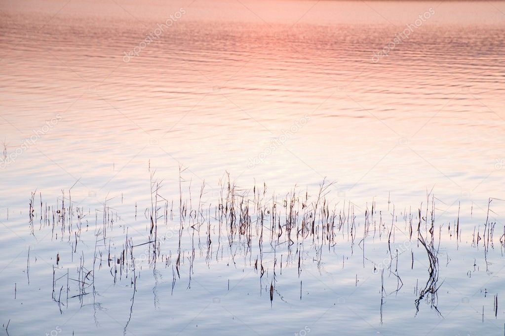 Beautiful autumn sunrise or sunset with Reflection on Lake water level. Gentle waves.