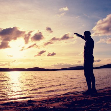 Sporcu standi sıcak sportif giyim gün batımında defne sahilde. Sonbahar başlar, sezon sonu.