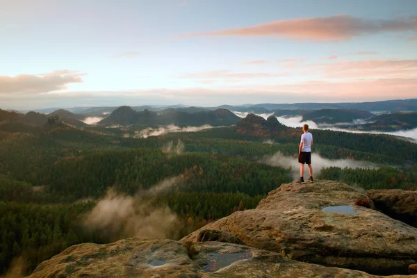 Man in white shirt and black  pants  stand on rock in national park and watch to  beautiful moment — Stock Photo, Image