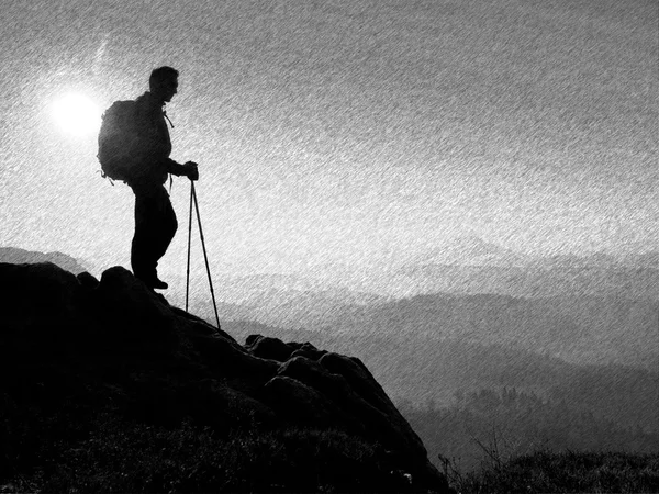 Esbozo retro rayado en blanco y negro. Turista con mochila deportiva y bastones en las manos de pie en el punto de vista rocoso — Foto de Stock