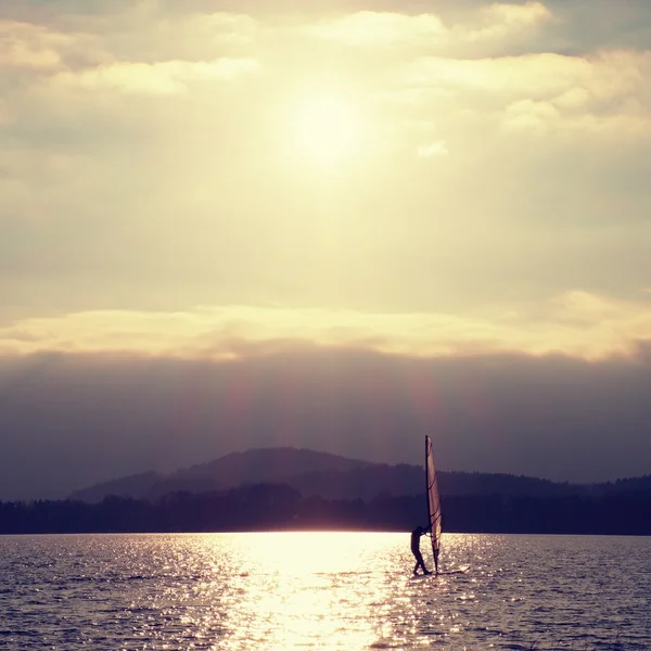 Windsurfer se penche de nouveau dans la brise Tourné avec un filtre doux . — Photo