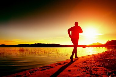 Spor ve sağlıklı yaşam tarzı sahil şeridi boyunca inanılmaz yaz günbatımında çalışan sporcu