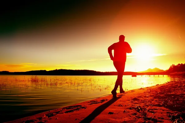Sportsman courir à incroyable coucher de soleil d'été le long de la côte dans le sport et le mode de vie sain — Photo
