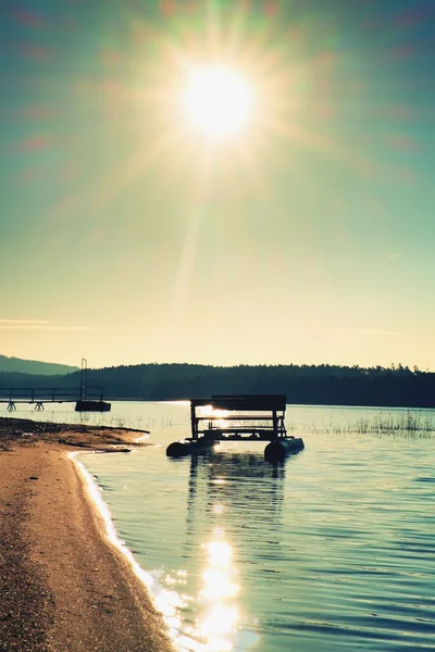 Övergiven gammal rostig paddel båt fastnat på sand på stranden. Vågigt vatten, ö vid horisonten. — Stockfoto