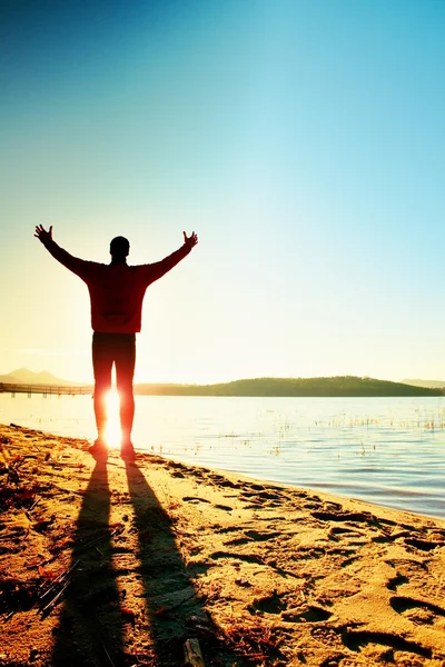 Silhouet van sport actieve man uitgevoerd en uitoefenen op het strand bij zonsondergang. — Stockfoto