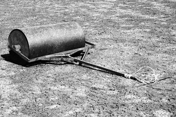 Black and white dashed retro sketch. Old rusty iron barrel for maintenance of neglect tennis court. Outdoor tennis ground. — Stock Photo, Image