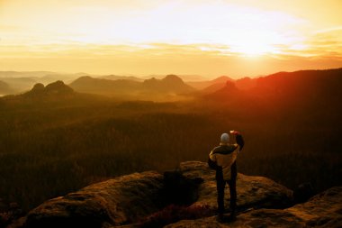 Adam akıllı telefon ile fotoğraf rock İmparatorluğu'nun peak alır. Rüya gibi adamlara manzara, Bahar turuncu bir güzel vadi Saksonya'nın İsviçre parkta.