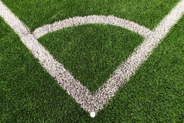 Campo da calcio angolo su tappeto erboso verde artificiale con segni di linea bianca dipinta. Gomma nera macinata in base . — Foto Stock