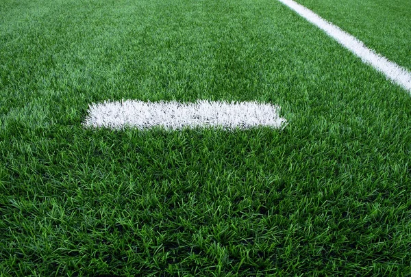 白線マークは、緑の人工芝の背景に描かれました。プラスチック芝生の遊び場. — ストック写真