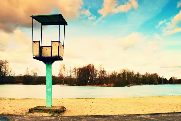 Старая белая и ржавая металлическая спасательная башня со стулом на пляже. Уровень замерзшей воды в колдовстве — стоковое фото