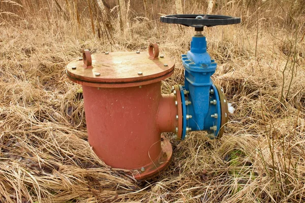 Gamle ekspansionsrør af drikkevandsrør sammen med ny blå ventil og nye blå fælles medlemmer. Ny dumpningsventil . - Stock-foto