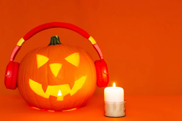 Happy carved pumpkin Halloween decorations festival and music concept background.Mix variety pumpkin listening radio by headphone on orange background.
