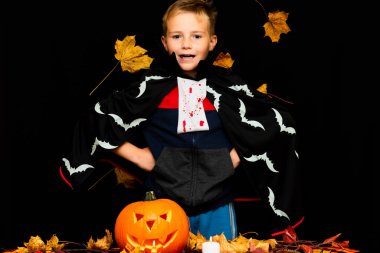 Gülen surat, Cadılar Bayramı kostümü giymiş, siyah sarı yapraklı balkabağı feneri gibi giyinmiş genç adam kostümü. Stüdyo çekimi..