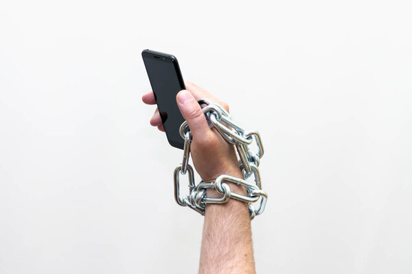 Закрыть Мужчина держит смартфон с металлической цепью на белом фоне. Концепция безопасности, Студия съемки.