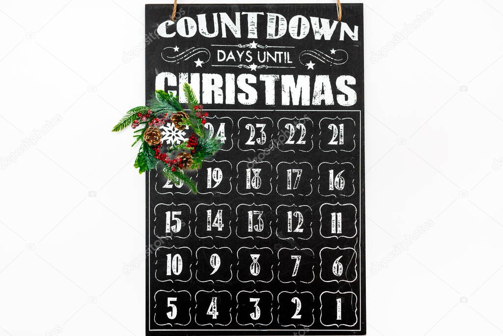 Christmas wreath on wooden advent calendar showing Christmas countdown top view flat lay white background.