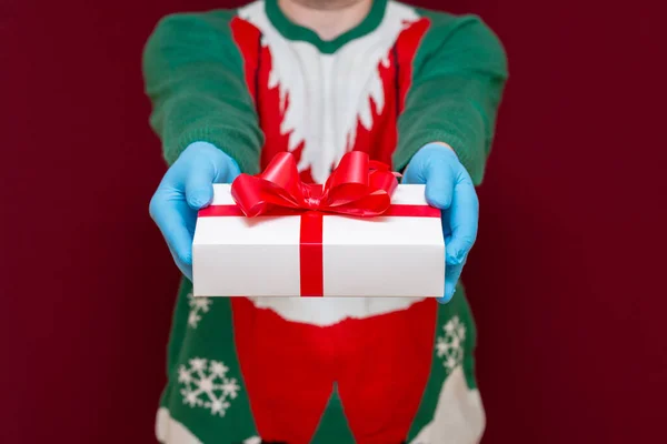 在红色工作室的背景上 男性手拿着白色礼品盒的近照 圣诞概念 — 图库照片
