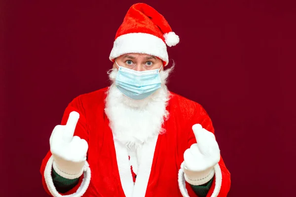 坏圣诞老人露出中指 他戴着医疗面具 红墙工作室 — 图库照片