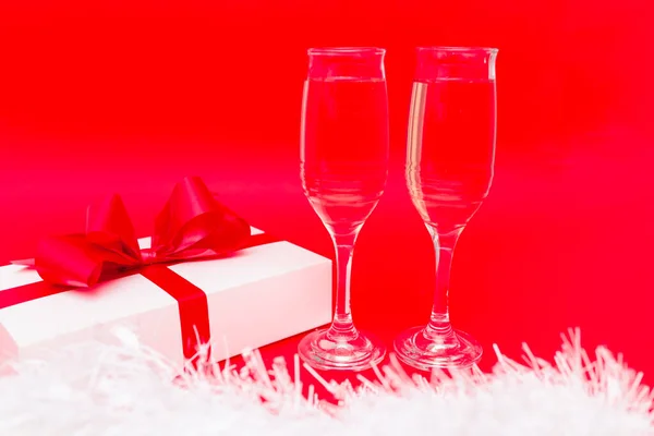 Zwei Gläser Mit Champagner Geschenkbox Und Weißer Weihnachtsdekoration Auf Rotem — Stockfoto